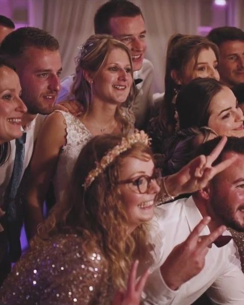Des invités d'un mariage sourient face à l'objectif de la borne